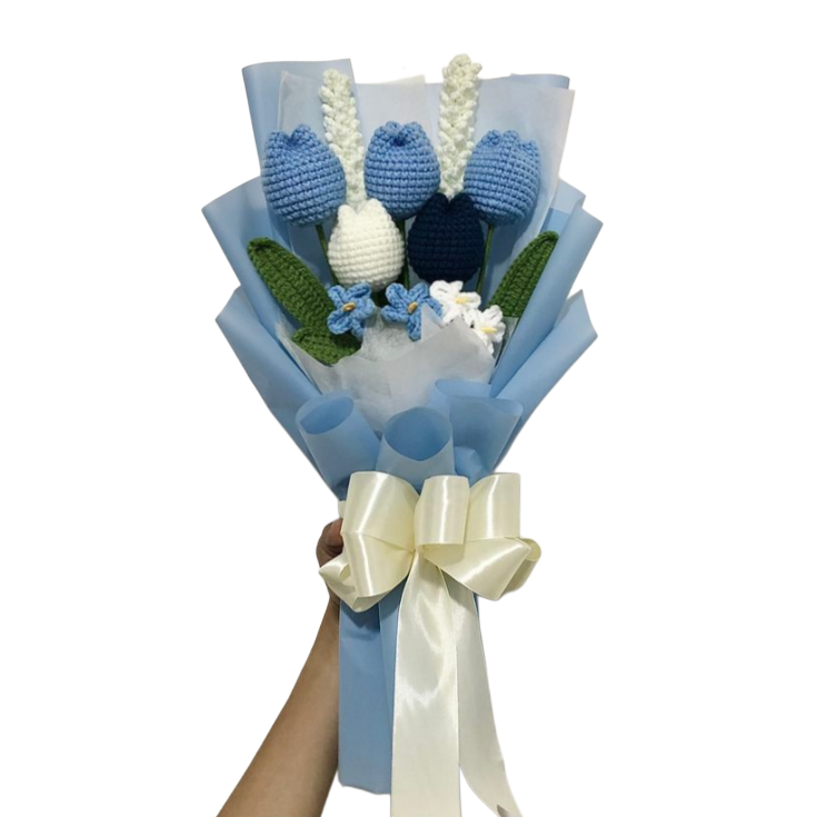 A handmade crochet bouquet featuring frosted pink and white tulips wrapped in premium floral paper.